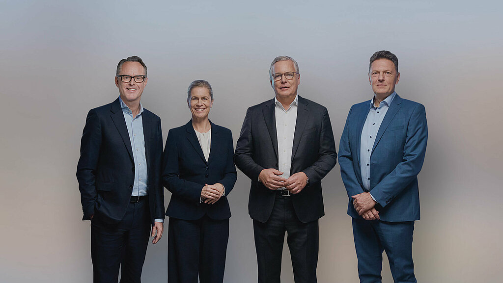 Vorstandsfoto mit Steffen Hoffmann (CFO), Inge Hofkens (COO), Dr. Toralf Haag (CEO), Tim Kurth (COO) im schwarzen Anzug und Kleid