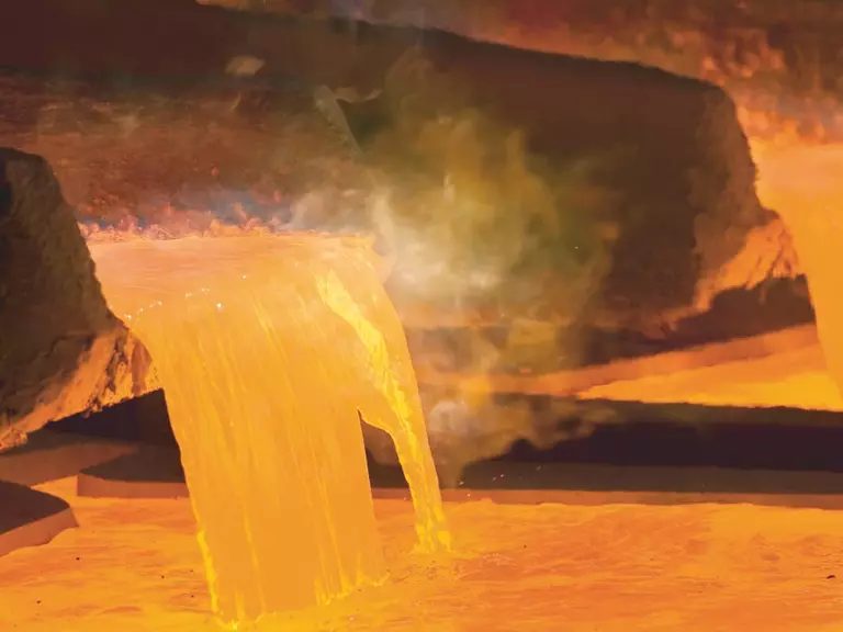 Heißes Flüssigkupfer, das in ein dampfendes Becken gegossen wird